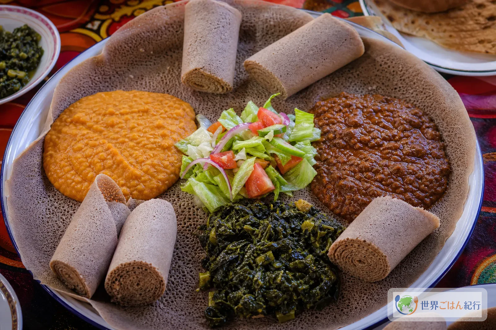 インジェラ、青菜、豆料理と一緒に並べたエチオピア風の食卓
